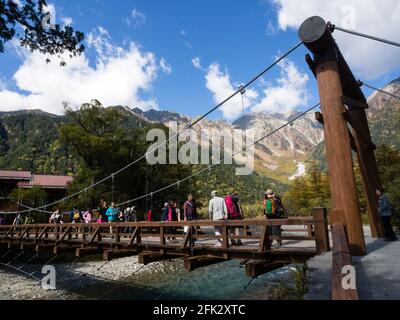 Mtsumoto, Japan - 7. Oktober 2015: Touristen überqueren die Kappa-Bashi-Brücke im malerischen Kamikochi-Tal Stockfoto