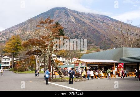 Nikko, Japan - 25. Oktober 2016: Souvenirstände und Lebensmittelhändler am Eingang zu den berühmten Kegon-Fällen im Nikko-Nationalpark mit dem Berg Nantai Stockfoto