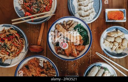 Zwei Schüsseln schmackhafter asiatischer Ramen-Nudelsuppe mit Rinderbrühe, Huhn, Ei mit Eigelb auf Holzhintergrund, Nahaufnahme, Draufsicht. Japanische heiße Ramen-Suppe f Stockfoto