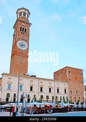 Die kleinen Marktstände auf der Piazza Erbe Platz vor dem mittelalterlichen Palazzo Ragione Palast mit hohen Backstein Lamberti Uhrturm, dominierende Bereich, Ve Stockfoto