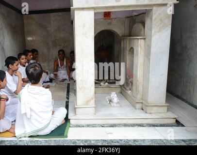 Brahmanen-Jungen studieren einen heiligen Text in einem kleinen Tempel in der Altstadt von Varanasi, Indien. Stockfoto