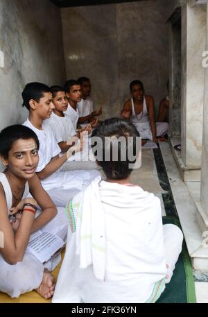 Brahmanen-Jungen studieren einen heiligen Text in einem kleinen Tempel in der Altstadt von Varanasi, Indien. Stockfoto