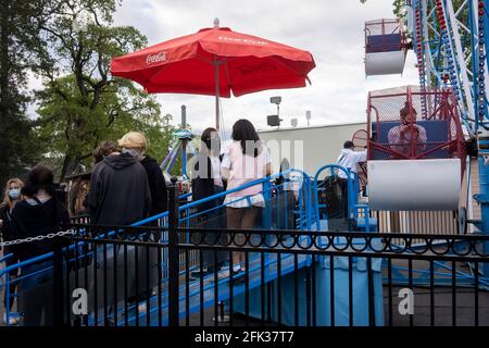 Maskierte Besucher im Oaks Amusement Park in Portland, der am Sonntag, den 25. April 2021, während eines Pandemiefrühlings, unter Einhaltung der COVID-Vorgaben wieder eröffnet wird. Stockfoto