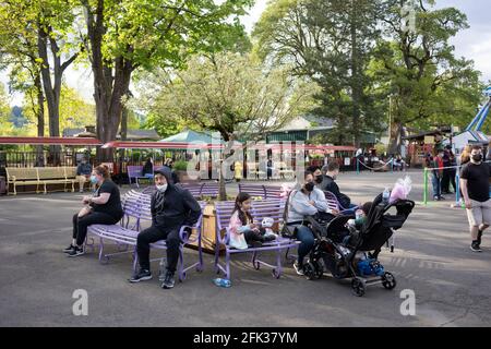 Maskierte Besucher im Oaks Amusement Park in Portland, der am Sonntag, den 25. April 2021, während eines Pandemiefrühlings, unter Einhaltung der COVID-Vorgaben wieder eröffnet wird. Stockfoto