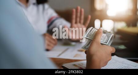 Geschäftsfrau Ablehnung Geld in weißem Umschlag von seinem Partner im Dunkeln angeboten - Anti-Bestechung-Konzept. Stockfoto