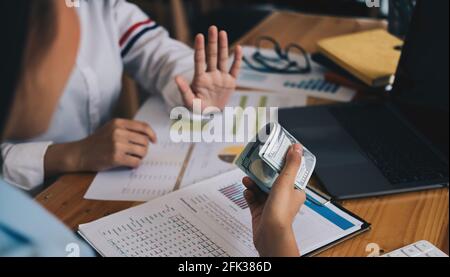 Geschäftsfrau Ablehnung Geld in weißem Umschlag von seinem Partner im Dunkeln angeboten - Anti-Bestechung-Konzept. Stockfoto