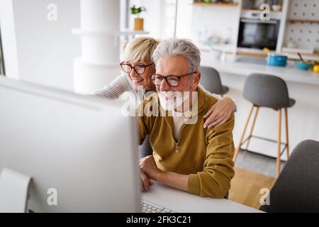 Fröhliche ältere Paar mit Technologie-Geräte und Spaß an Zu Hause Stockfoto
