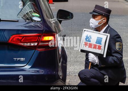 Tokio, Japan. April 2021. Ein Parkplatzleitspersonal fordert die Menschen auf, im Einkaufsviertel Ginza während der jährlichen „Goldenen Woche“ in Japan Gesichtsmasken zu tragen. (Foto von James Matumoto/SOPA Images/Sipa USA) Quelle: SIPA USA/Alamy Live News Stockfoto