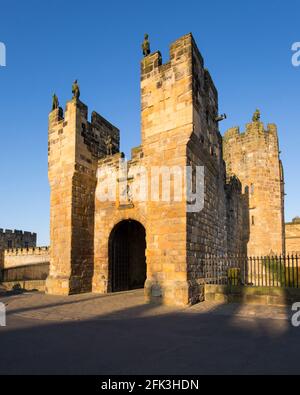 Alnwick, Northumberland, England. Der barbican aus dem 14. Jahrhundert und das Torhaus von Alnwick Castle, Sonnenuntergang. Stockfoto