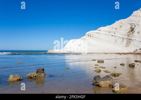 Realmonte, Agrigento, Sizilien, Italien. Blick über die Bucht auf die Scala dei Turchi, weiße Kalksteinfelsen, die sich im ruhigen Meer spiegeln. Stockfoto