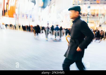 Tokio, Japan - 13. Dezember 2015: Abstraktes Bild eines stilvollen Gentleman am Shibuya Crossing in Tokio, Japan. Stockfoto