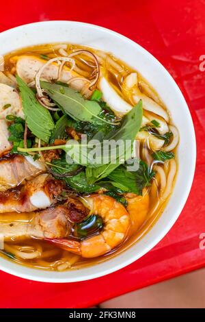 Vertikales Foto von köstlicher vietnamesischer Fischbrühe Nudelsuppe, Bun Mam Stockfoto