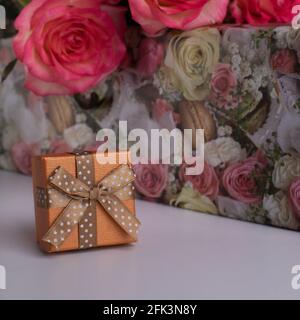 Goldfarbene Geschenkbox für Schmuck und rosa Rosen. Schmuckkisten. Überraschung für Ihre Freundin Stockfoto