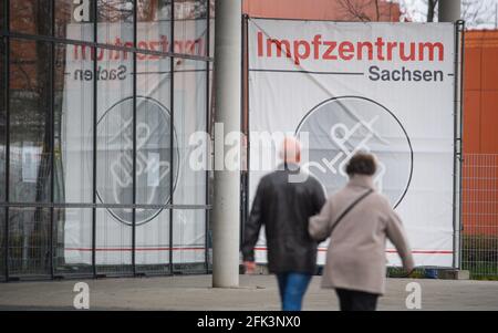 Dresden, Deutschland. April 2021. Ein Mann und eine Frau gehen vor das Impfzentrum Sachsen der Messe Dresden. In Sachsen wurden an einem Tag fast 39,000 Menschen gegen das Coronavirus geimpft, ein neuer Tagesrekord. Quelle: Robert Michael/dpa-Zentralbild/ZB/dpa/Alamy Live News Stockfoto