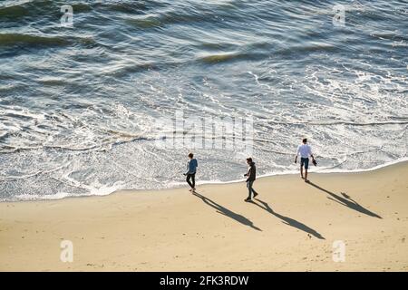 Drei Freunde schlendern an einem Strand von oben gesehen Stockfoto