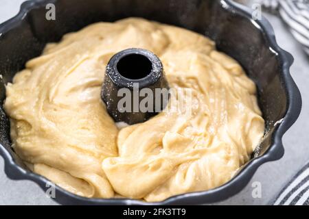 Zitronenpfaumteig in einer gebrannten Backform, fertig zum Backen. Stockfoto