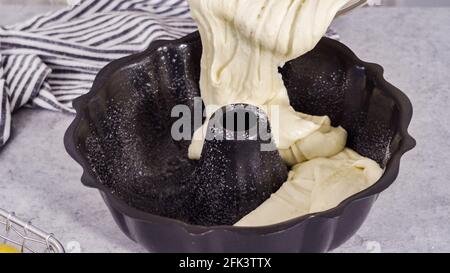 Zitronenpfaumteig in einer gebrannten Backform, fertig zum Backen. Stockfoto