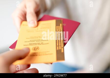 Reisender, der seinen internationalen Pass und seine Bescheinigung über Immunität und Impfung am Flughafen zur Reise übergibt. Concept Coronavirus, covid-19 Stockfoto