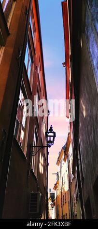 Enger Raum zwischen zwei hohen Gebäuden mit einer Laterne auf dem blauen Himmel Hintergrund, Stockholm Stockfoto