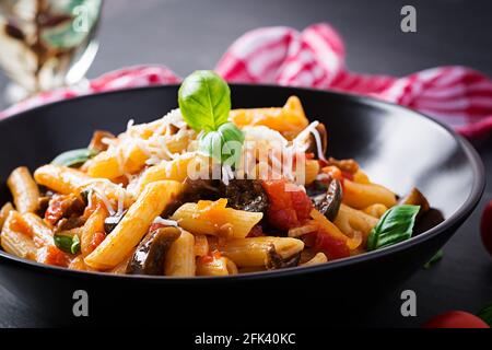 Pasta Penne mit Auberginen. Pasta alla norma – traditionelle italienische Küche mit Auberginen, Tomaten, Ricotta-Käse und Basilikum. Stockfoto