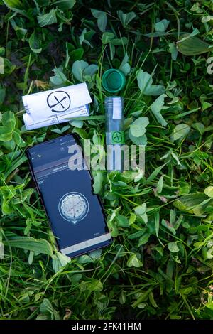Vertikale Aufnahme von Geocaching-Werkzeugen (Schatzsuche) auf Pflanzen Stockfoto