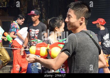 Songkran, thailändisches Neujahr, während dessen Einheimische und Touristen durch die Straßen schlendern und Wasserstrahlen und Wasserballons austauschen. Eine echte Straßenparty Stockfoto