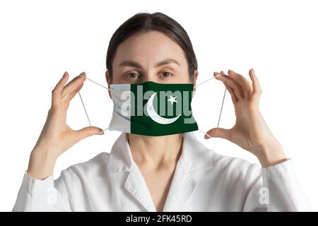 Atemschutzmaske mit Flagge des pakistanischen Arztes setzt auf medizinische Gesichtsmaske isoliert auf weißem Hintergrund. Stockfoto