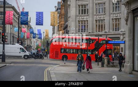 Oxford Street, London, Großbritannien. 28. April 2021. Londoners kehren in die Einkaufsstraßen des West End zurück, während sich die Covid-Sperre entspannt, und an einem langweiligen Tag mehr Verkehr und Fußgänger um den Oxford Circus herum sind. Bild: Der Verkehr fährt die Regent Street entlang und überquert die Kreuzung Oxford Circus. Quelle: Malcolm Park/Alamy Live News Stockfoto