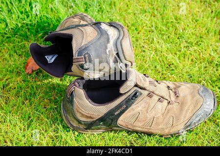 Ein paar gut benutzte Wanderschuhe, die das fehlende Profil auf den Sohlen zeigen. Stockfoto