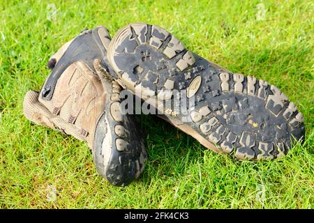 Ein paar gut benutzte Wanderschuhe, die das fehlende Profil auf den Sohlen zeigen. Stockfoto