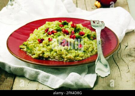 Risotto mit Brokkoli und Granatapfelkernen Stockfoto