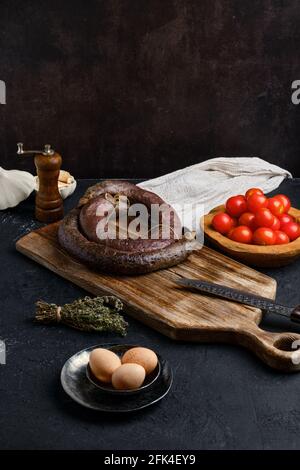 Blutwurst auf Holzschneidebrett gerollt Stockfoto