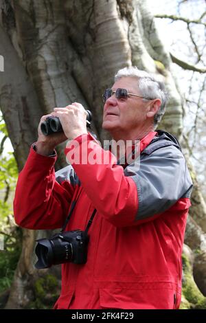 Vogelbeobachter und Fotograf im Park mit Kamera und Fernglas. Stockfoto