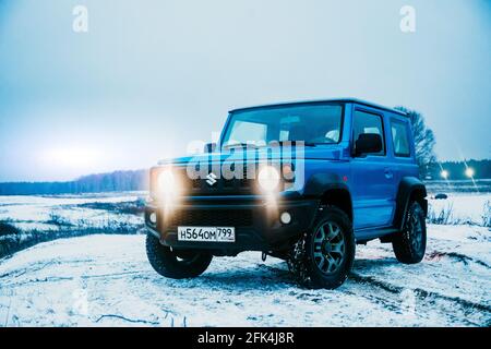 Moskau, Russland - 24. Januar 2020: Neuer Suzuki Jimny Mini-SUV auf Winterstraße am Abend. Japanische Suzuki SUV mit Scheinwerfer an. Keine Menschen. Stockfoto