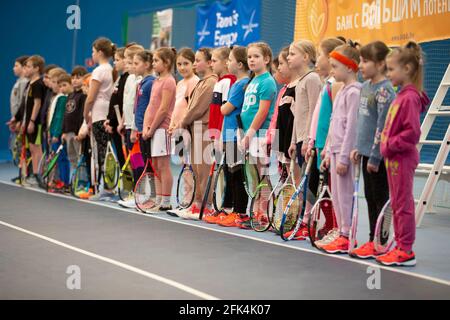 01. April 2021. Weißrussland, die Stadt Gomil. Wettbewerbe für Kinder im großen Tennis. Eine Gruppe von Kindern steht auf einem Tennisplatz mit Tennisschlägern. Stockfoto