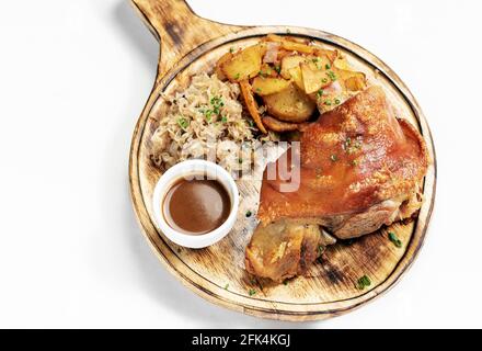 Weinshax traditionelle deutsche Schweinshaxe mit Sauerkraut und Kartoffelgericht Auf weißem Hintergrund Stockfoto