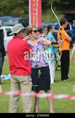 Ayr Archery Club veranstaltete einen Tag der offenen Tür „Kommen Sie und versuchen Sie Bogenschießen“ im J.Mowatt Playing Fields Doonside, Ayr Moira Jones veröffentlicht ihren Pfeil unter den wachsamen Augen von Willie Roney Stockfoto