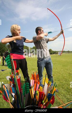 Ayr Archery Club veranstaltete einen Tag der offenen Tür „Kommen Sie und versuchen Sie Bogenschießen“ im J.Mowatt Playing Fields Doonside, Ayr Helen Cresswell ein Trainer mit Ayr Archery Club zeigt David Clacherie von Ayr, wie man einen Bogen benutzt Stockfoto