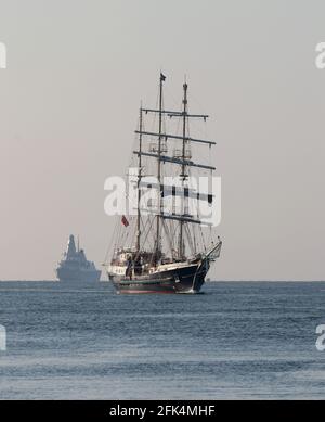 Das Segeltrainingsschiff SV TENACIOUS und die Royal Navy Zerstörer HMS DIAMOND nähert sich dem Marinestützpunkt Stockfoto