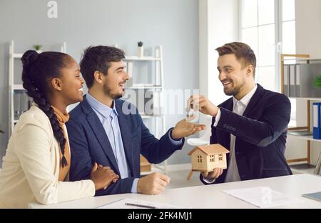 Makler Agent geben nach Hause Schlüssel zu glücklich lächelnd multirassischen Paar Kunde Stockfoto