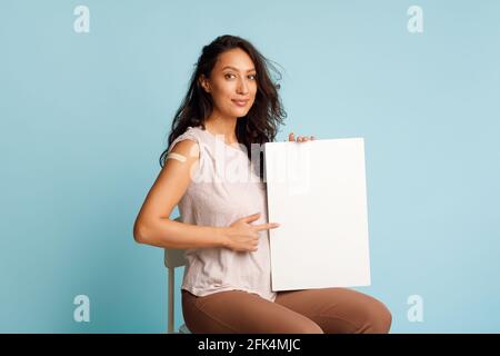 Geimpfte Frau Mit Leerem Papierbrett Auf Blauem Hintergrund Stockfoto