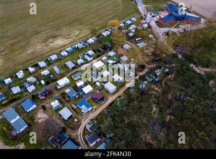 Pepelow, Deutschland. April 2021. Wohnwagen und Zelte von Dauercamper stehen auf dem Gelände des Ostseecamp 'am Salzhaff'. Aufgrund der Corona-Schutzmaßnahmen sind die Campingplätze in Mecklenburg-Vorpommern derzeit geschlossen, auch Dauercamper dürfen nicht in ihren Wohnwagen oder Zelten übernachten. (Luftaufnahme mit Drohne) Quelle: Jens Büttner/dpa-Zentralbild/ZB/dpa/Alamy Live News Stockfoto