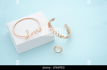 Love Wort Form Armband auf weißem Feld auf blauem Hintergrund Stockfoto