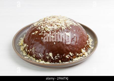 Hausgemachter Schokoladenkäsekuchen mit Mandelscheiben auf weißem Holztisch. Stockfoto