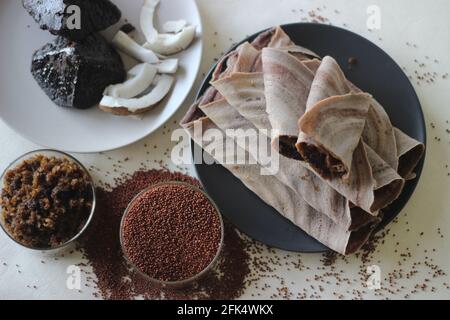 Fingerhirse-Crepes mit frisch geriebener Kokosnuss- und Palmsackfüllung. Aufgenommen auf weißem Hintergrund. Stockfoto