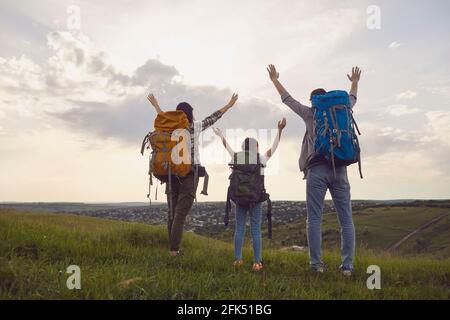 Glückliche Familie mit Rucksäcken über die Natur bei Sonnenuntergang. Wandern Familien Tourismus Konzept. Stockfoto
