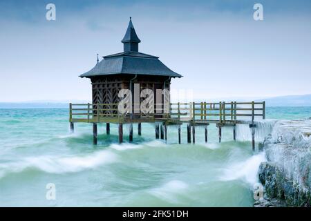 Vereistes Holz Badehaus bei stürmischem Wind am Neuenburgersee in Gorgier, Neuenburg, Schweiz Stockfoto