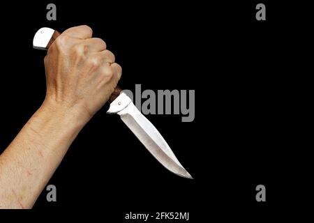 Messer mit menschlicher Hand isoliert auf schwarz. Copyspace. Stockfoto