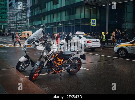 Zwei Motorräder bei Regenwetter auf einem Parkplatz neben dem Moskauer Geschäftsviertel: Moskau, Russland - 21. April 2021 Stockfoto