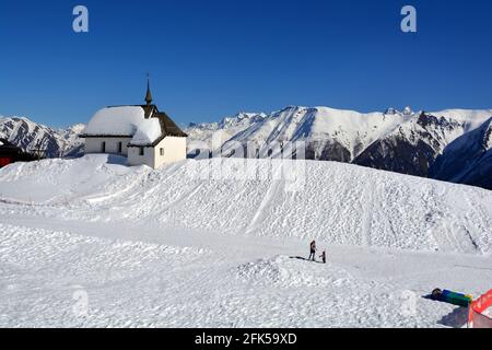 Eine Kapelle in den Alpen im Winter mit Blick auf die Berge der Schweizer Bergdorf Bettermalp Stockfoto